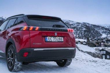 Rauland, Norveç - 14 Ocak 2022: Kırmızı elektrikli otomobil Peugeot e-2008 GT yeni bir SUV elektrikli otomobil.. 
