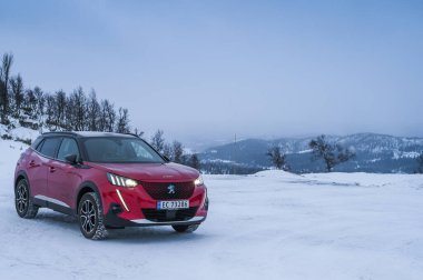 Rauland, Norveç - 14 Ocak 2022: Kırmızı elektrikli otomobil Peugeot e-2008 GT yeni bir SUV elektrikli otomobil.. 