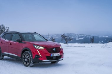 Rauland, Norveç - 14 Ocak 2022: Kırmızı elektrikli otomobil Peugeot e-2008 GT yeni bir SUV elektrikli otomobil.. 