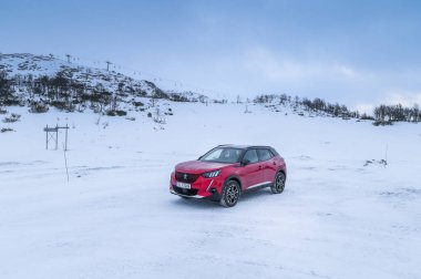 Rauland, Norveç - 14 Ocak 2022: Kırmızı elektrikli otomobil Peugeot e-2008 GT yeni bir SUV elektrikli otomobil.. 
