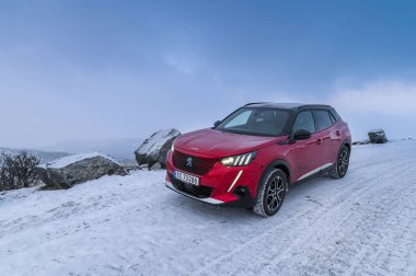 Rauland, Norveç - 14 Ocak 2022: Kırmızı elektrikli otomobil Peugeot e-2008 GT yeni bir SUV elektrikli otomobil.. 
