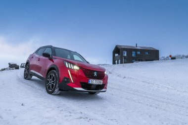 Rauland, Norveç - 14 Ocak 2022: Kırmızı elektrikli otomobil Peugeot e-2008 GT yeni bir SUV elektrikli otomobil.. 