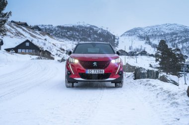 Rauland, Norveç - 14 Ocak 2022: Kırmızı elektrikli otomobil Peugeot e-2008 GT yeni bir SUV elektrikli otomobil.. 