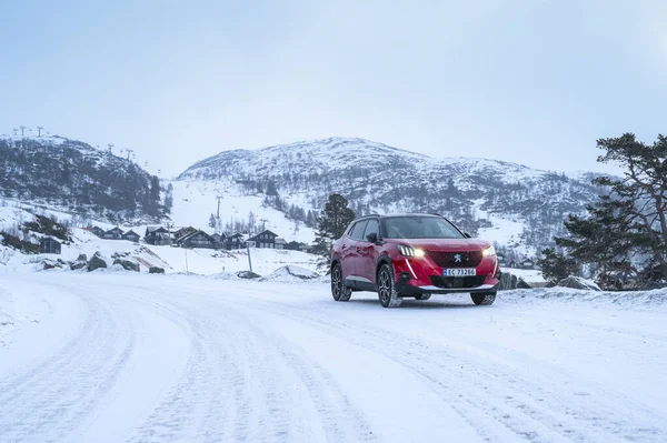 Rauland, Norveç - 14 Ocak 2022: Kırmızı elektrikli otomobil Peugeot e-2008 GT yeni bir SUV elektrikli otomobil.. 