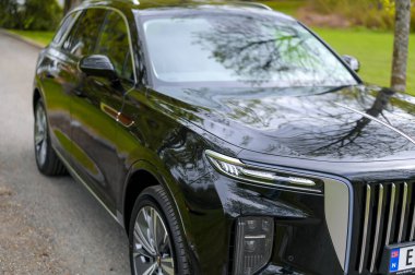 Notteroy, Norway - may 27, 2022: black electric SUV Hongqi around green foilage 