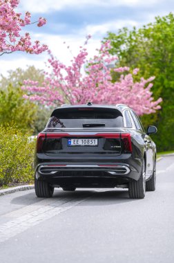 Notteroy, Norway - may 27, 2022: black electric SUV Hongqi around green foilage 