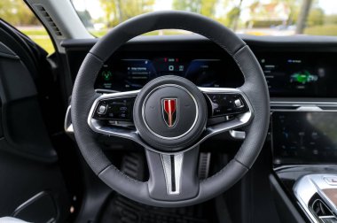 Notteroy, Norway - may 27, 2022: black electric SUV Hongqi around green foilage 