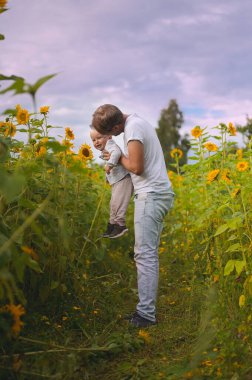 happy fatherhood in the sunflower field. son and father with glasses