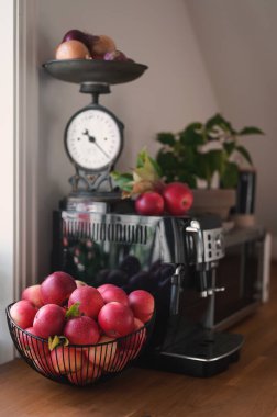 Şık mutfak masasında kırmızı sulu elmalar. Mutfak dengesi ve kofemashin.