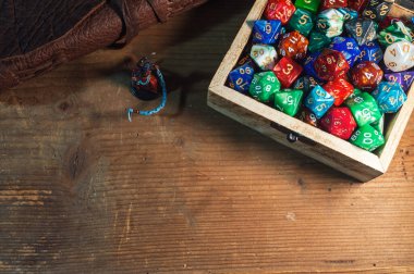 Rol yapma zarları, deri bir kitap ve oyun biblosuyla dolu ahşap bir kutuyla roket oyunu sahnesi..