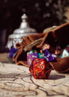 20 kenarlı kırmızı bir rol yapmanın dikey görüntüsü arka planda bir zar çantası içinde ölür