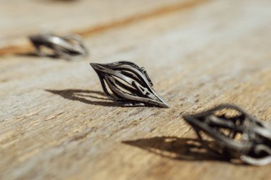 Güneş altında tahta bir yüzeye damlacık şeklinde metal RPG zarları.