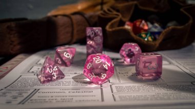 Karakter tablosundaki pembe şeffaf RPG zar setinin resmi