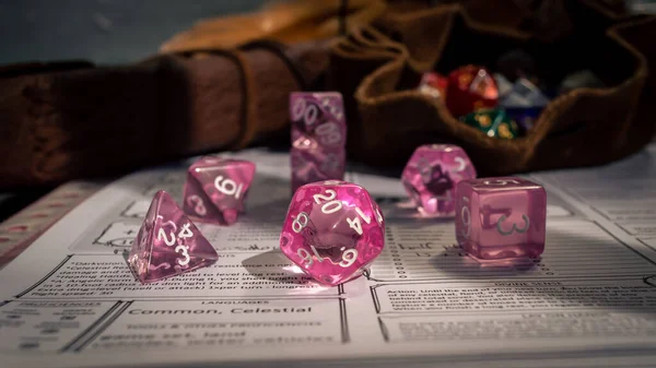 Karakter tablosundaki pembe şeffaf RPG zar setinin resmi