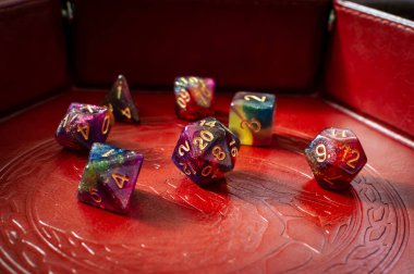 Kahverengi deri bir zar tepsisindeki renkli oyun zarlarının yakın plan görüntüsü.