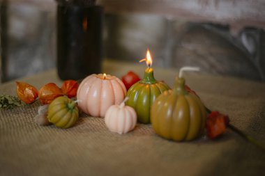 Cadılar Bayramı için balkabağı şeklinde mumlar, beyaz, altın balkabakları ve yanan mumlar, romantik bir akşamın sihirli atmosferi, Cadılar Bayramı konsepti..