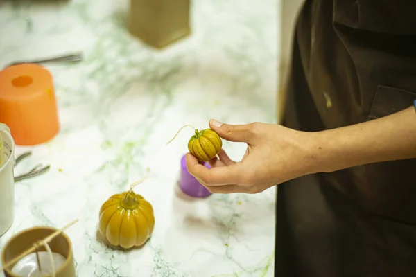 the process of making a pumpkin candle for Halloween, the concept of preparing for Halloween on Memorial Day.