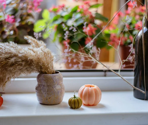 ハロウィンの準備 カボチャの形のキャンドル 窓辺に乾いた花束の花瓶 ハロウィーンと記念の日の期待の雰囲気 キャンドルの居心地の良い構成 — ストック写真