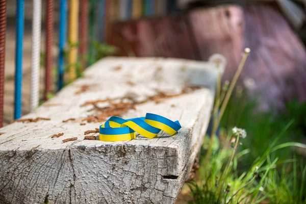 Tahta beyaz bir bankta sarı ve mavi kurdele, Ukrayna bayrağının renkleri özgürlük, cesaret ve bağımsızlık mücadelesinin sembolü..