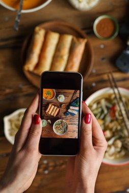 Tayland yemeğiyle fotoğraf çeken kadın eller.