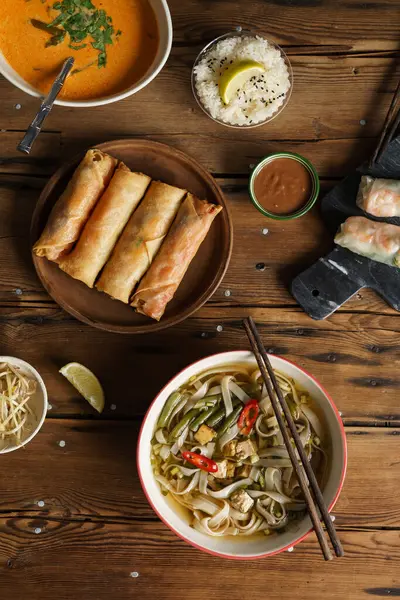 Tofulu vejetaryen şehriye çorbası, fasulye filizi, filizli börek, Tom yer elması. Ahşap bir masa arkasında Asya tarzı yemek. dikey