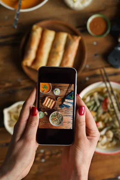 Tayland yemeğiyle fotoğraf çeken kadın eller.