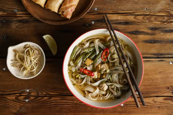 Tofulu vejetaryen şehriye çorbası, fasulye filizi. Ahşap bir arka planda Asya tarzı yemek.