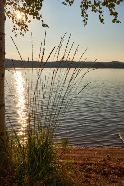 Güneşin gölde yansıttığı güzel bir gün batımı.