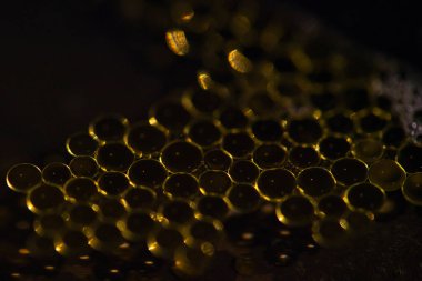 Oil drops on a water surface with dark background