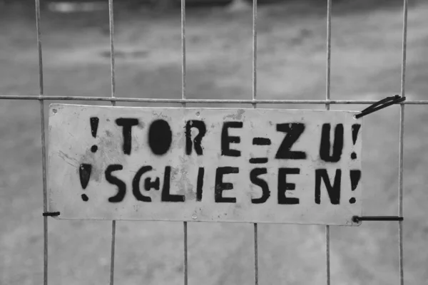 A sign with german text at a gate that means close the gate, misspelled tried to improve, but unsuccessfully. — Zdjęcie stockowe