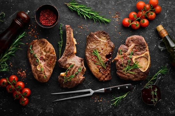 Barbecue menu. Grill steaks. Top view. Flat lay top view on black stone cutting table. Stock Image Everypixel