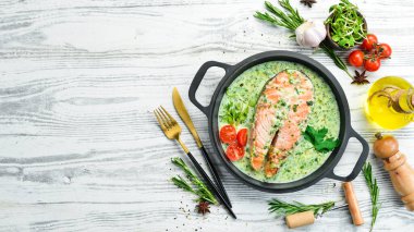 Kremalı ıspanak soslu somon bifteği. Restoran yemeği. Deniz ürünleri. Kırsal tarzda. Düz Yat.