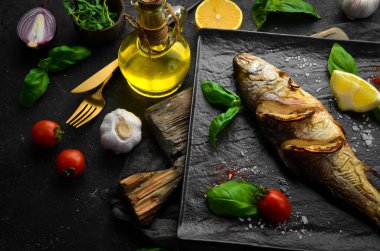 Siyah taş tabakta limonlu ve sebzeli fırında alabalık. Deniz ürünleri. Nehir balığı. Üst görünüm.