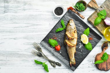 Siyah taş tabakta limonlu ve sebzeli fırında alabalık. Deniz ürünleri. Nehir balığı. Üst görünüm.