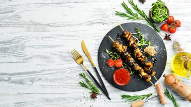 Siyah taştan bir tabakta sebzeli Rapana şişleri. Restoran yemeği. Deniz ürünleri. Kırsal tarzda. Düz Yat.
