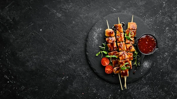 Siyah taş tabakta teriyaki soslu tavuk şişleri. Kırsal tarzda. Barbekü menüsü.