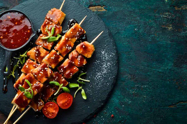 Siyah taş tabakta teriyaki soslu tavuk şişleri. Kırsal tarzda. Barbekü menüsü.