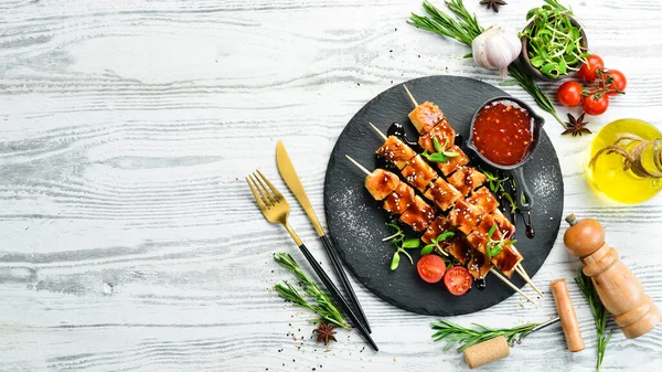 Siyah taş tabakta teriyaki soslu tavuk şişleri. Kırsal tarzda. Barbekü menüsü.
