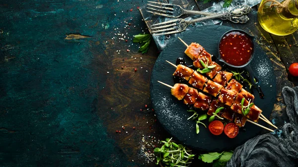 Siyah taş tabakta teriyaki soslu tavuk şişleri. Kırsal tarzda. Barbekü menüsü.