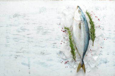 Baharatlı ve otlu çiğ ton balığı. Deniz mahsulleri pişiriyorum. Beyaz mutfak arka planında. Üst görünüm.