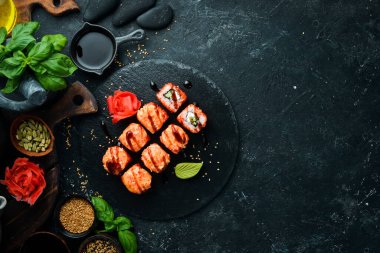Black Stone tabağında geleneksel suşi rulosu iştah açıcı. Japon mutfağı. Üst görünüm.