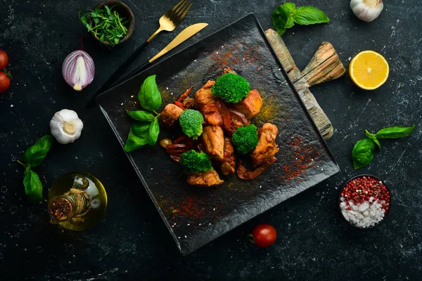 Şarap soslu et, brokoli ve siyah taş tabakta sebze. Üst görünüm.