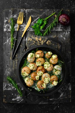 Sarımsaklı Bourgogne Salyangoz, siyah taş tabakta krem soslu peynir. Üst Manzara. Metin için boş alan.