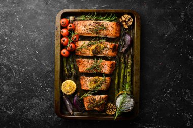 Metal bir tepside sebze ve biberiyeyle pişirilmiş somon balığı. Yemek tarifi. Deniz ürünleri. Metin için boş alan.