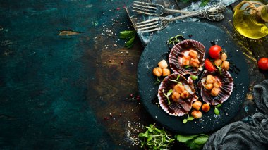 Kabuklu deniz tarağı ve siyah taş bir tabakta sebze. Lüks restoran yemekleri. Deniz ürünleri. Kırsal tarzda. Düz Yat.