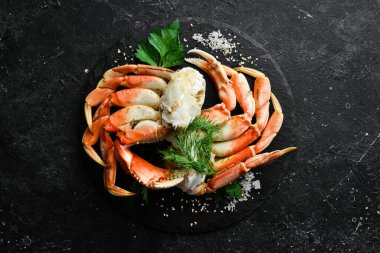 Yengeç pençesi. Kaynamış pençeler siyah bir taş plaka üzerinde. Kırsal tarzda. Deniz ürünleri lezzetleri..