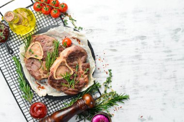 Osso buco beyaz ahşap arka planda baharat ve sebzelerle dana inciği pişirdi. Düz yatıyordu. Üst görünüm.