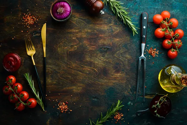 Black stone cooking background. Spices and vegetables. Top view. Free space for your text.