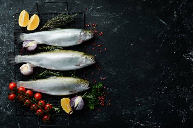 Baharatlı ve otlu alabalık balığı. Hazırlık. Karanlık bir mutfak geçmişinde. Üst görünüm.