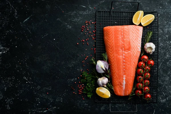 Biberiye ve baharatlı somon filetosu. Karanlık bir arka planda. Üst görünüm.